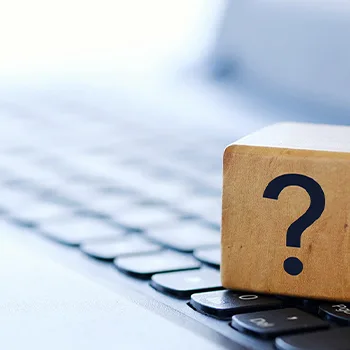 A wooden block displaying a question mark, symbolizing inquiry or curiosity.