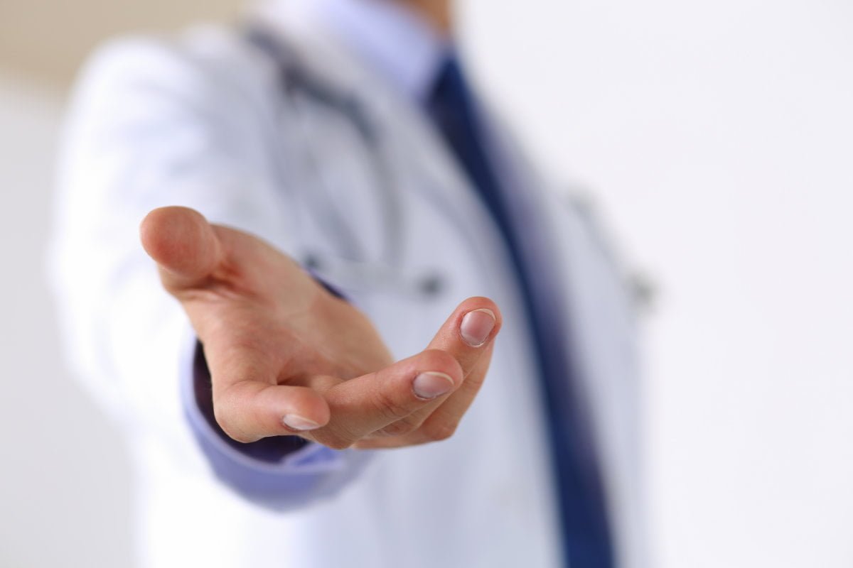 Doctor extending hand to recovery patient